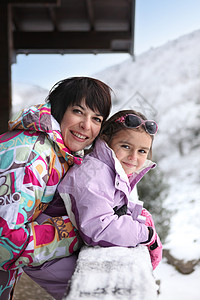 小女孩和母亲在他们的滑雪小屋图片