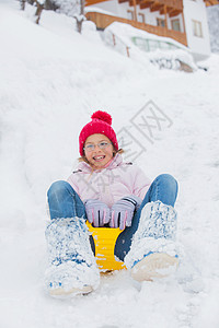 那女孩在雪坡上开车去兜风 童年 衣服 平底雪橇图片