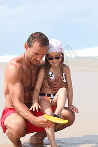 父亲和女儿在海滩玩耍图片