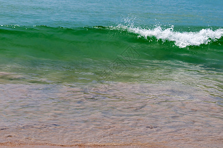 沙沙沙滩上的小小平静波浪图片