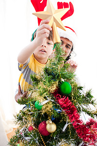 父亲和儿子把星星放在圣诞树的顶上 幸福 家庭背景图片