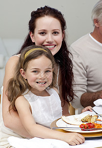 母亲和女儿与家人一起吃晚饭 享受 父亲 庆典 感恩图片