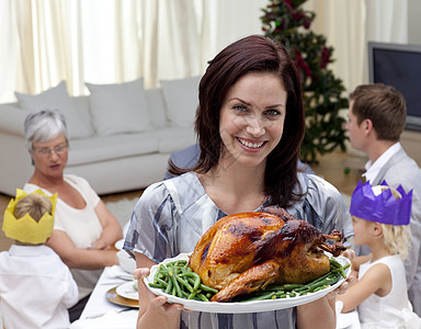 女人把圣诞火鸡当家用晚餐 午餐 祖父母 家庭 女儿图片