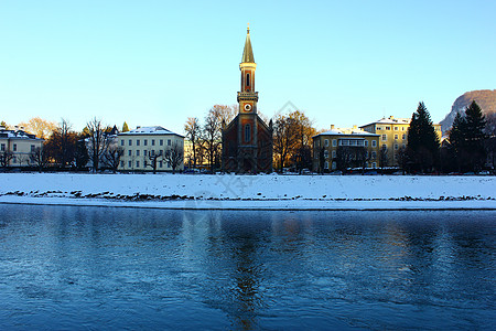 萨尔茨堡大教堂在奥地利萨尔茨堡的Salzach河上查看 城市 雪背景