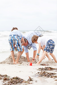 父亲和在海滩上的儿子们 在沙滩上玩耍 成人图片