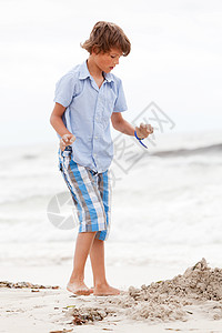小男孩在沙滩上玩沙子 闲暇 假期 支撑 阳光 海滩图片