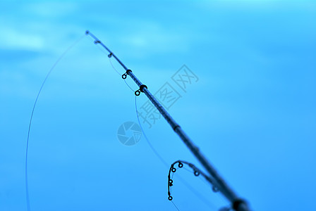 蓝水背景的鱼杆捕捞棒图片