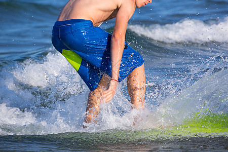 在海滩上冲浪的男孩 喷 爱好 娱乐 假期 游泳衣 前滩图片