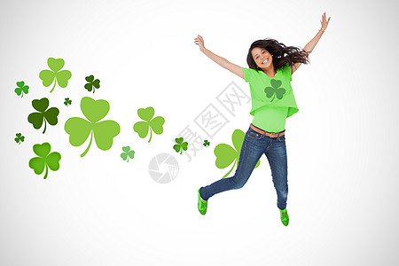 身穿绿色假汗衫的女孩为欢乐而跳跃背景图片