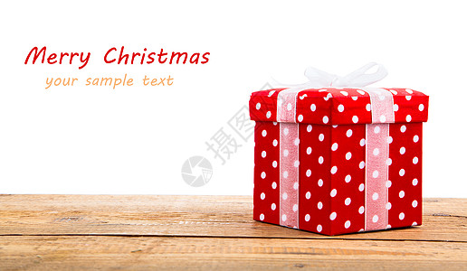 红色礼物盒 带白丝带 在木头上 在白色背景图片