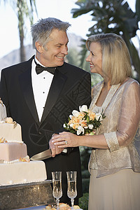 快乐的一对夫妇 切结婚纪念蛋糕在一起背景