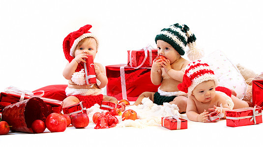 三个婴儿穿着Xma服装 玩礼物游戏 庆祝 快乐的图片