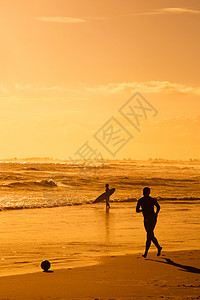 男孩在海滩上踢足球 夏天 波浪 水 日出 巴西 剪影图片