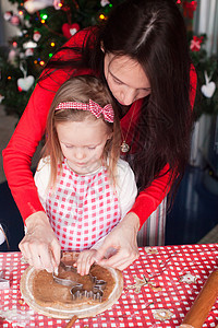 小女孩和年轻母亲一起烤圣诞姜饼饼干的年幼女孩 可爱的 手工制作的图片