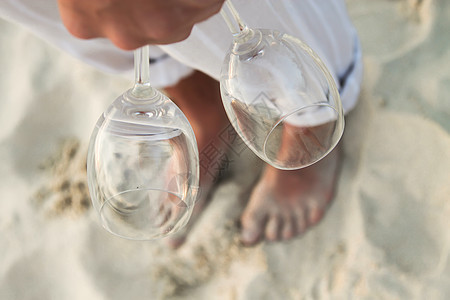 在海滩上赤脚走路的男子手握着两个杯子 紧闭两杯 红酒杯 夫妻图片