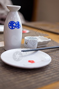 日式餐桌和清酒 瓶子 陶瓷制品 小清酒杯 喝 筷子 传统的图片