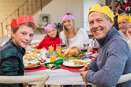 在晚饭桌上 带着党帽微笑大家族 桌子 家庭生活 儿子背景图片