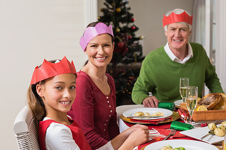 在晚饭桌上 带着党帽微笑大家族 圣诞节 晚餐 女孩背景图片