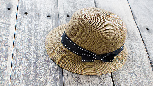 高贵的女子帽子或木地板上的女子海滩帽子图片