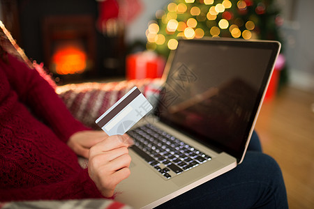 妇女在圣诞节用笔记本电脑在线购物 假期 花钱图片