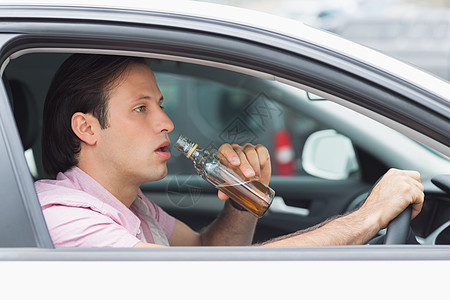 男人在开车时喝酒; 微醉 车辆 威胁生命 坐着 男性图片