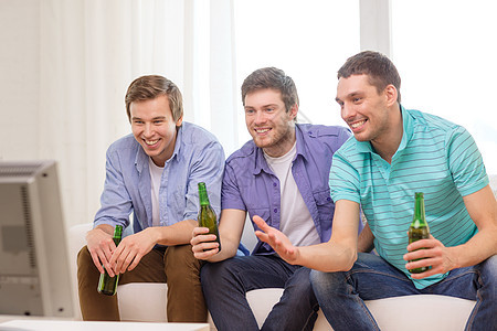 在家喝啤酒看电视的快乐男性朋友 朋友们 瓶子 粉丝图片