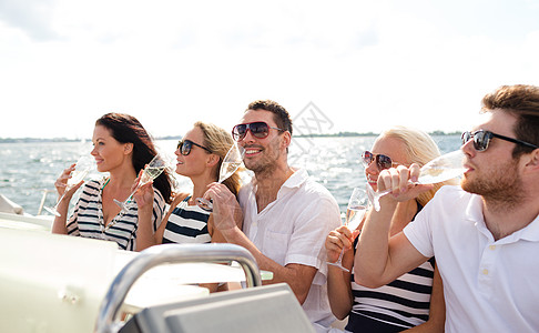 在游艇上带着香槟杯的笑着朋友 太阳镜 游客 眼镜图片