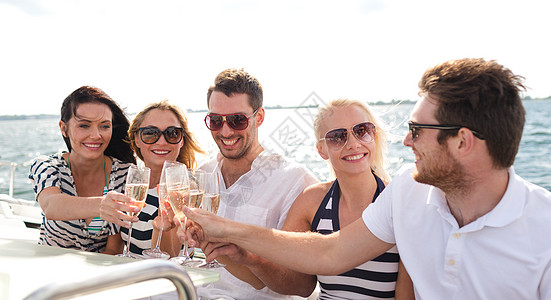 在游艇上带着香槟杯的笑着朋友 派对 闲暇 血管图片