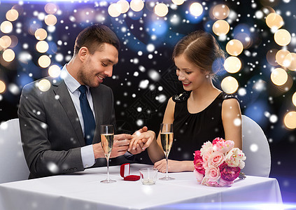 在餐厅微笑的夫妇与红色礼品盒 推杆 情人节 冬天图片