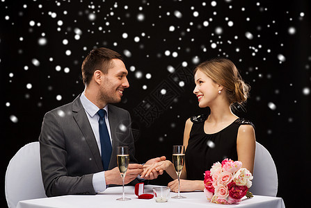 在餐厅微笑的夫妇与红色礼品盒 眼镜 盒子 冬天图片