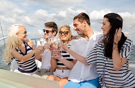 在游艇上带着香槟杯的笑着朋友 叮当作响 庆祝 海洋图片