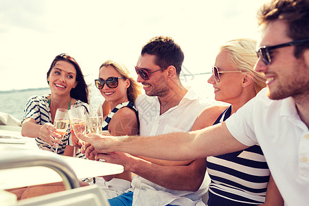 在游艇上带着香槟杯的笑着朋友 香槟酒 航行 船图片