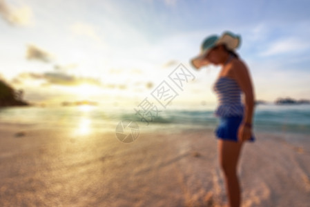 日出时沙滩上的模糊形象女人 热带 美丽的 闲暇图片