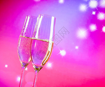 蓝色和紫色光灯底的金泡 香香槟长笛 迷人的 情人节图片