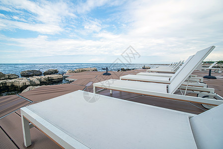 手绘大海岩石海滩的休息者 假期 天空 蓝色的 阳光 游客 椅子背景