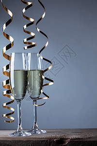 两杯香槟杯 金子 假期 卡片 金的 丝带 新年 喜庆的 玻璃背景图片