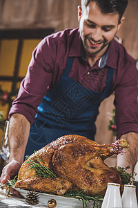 男人把火鸡放在节庆桌上 快乐的 肉 开胃 假期 感恩背景图片