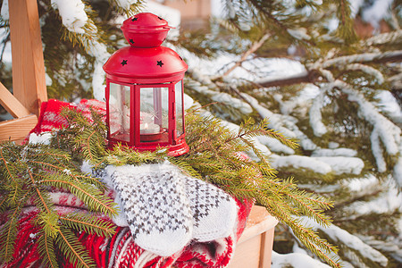 斯堪的纳维亚风格的羊毛手套在圣诞节上贴着木柴和红灯笼图片