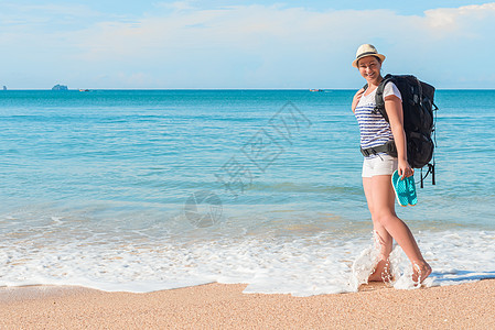 光着脚在海中带着背包的游客妇女图片