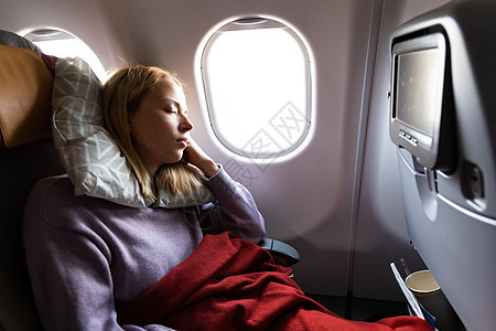 疲惫的金发休闲白种女士在乘飞机旅行时睡在座位上 飞机商业运输 窗户 空气图片