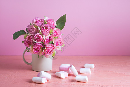 小白色和粉红色棉花糖散布在一朵玫瑰花瓶旁边的浅色粉色背景上 文本位置 甜点 母亲节图片