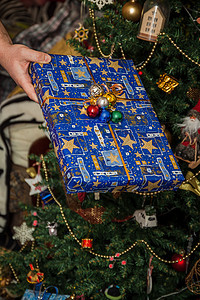 将礼物包在盛宴的圣诞树下 手握着装饰圣诞树 冬天 圣诞节图片