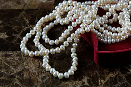 珍珠项链在一个红心形礼物盒里 在大理石背景上 生日 假期图片