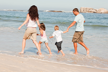家人在海滩上奔跑 恋人 父亲 浪漫的 母亲 跑步图片