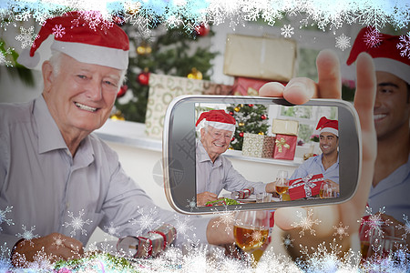 手持智能手机显示照片 圣诞大餐 混血 房子 计算机绘图 桌子图片