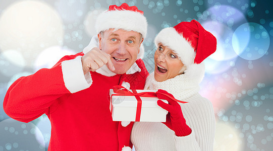 喜庆成年夫妇持有礼物的复合形象 圣诞帽 圣诞节的时候 假期图片