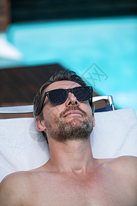 戴墨镜的帅哥在晒太阳休息员身上放松 旅行 晒黑图片