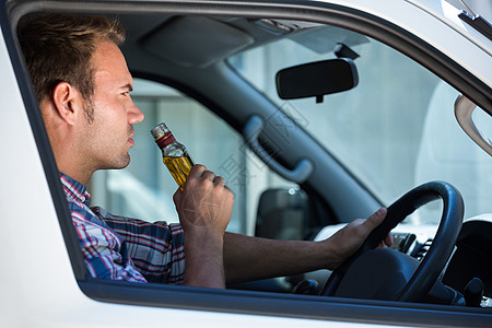 人开车时喝啤酒 驾驶 酒精 坐着 汽车 威胁生命 方向盘图片