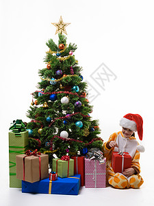 女孩在圣诞树上把圣诞礼物拆包图片