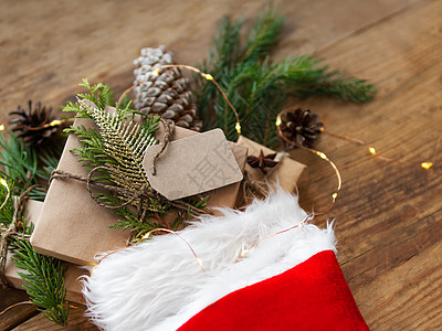 圣诞礼物在圣诞老人的红袜子里 手工艺纸上的礼物 有fir树枝和木制背景的清晰标记 短袜 羽毛图片